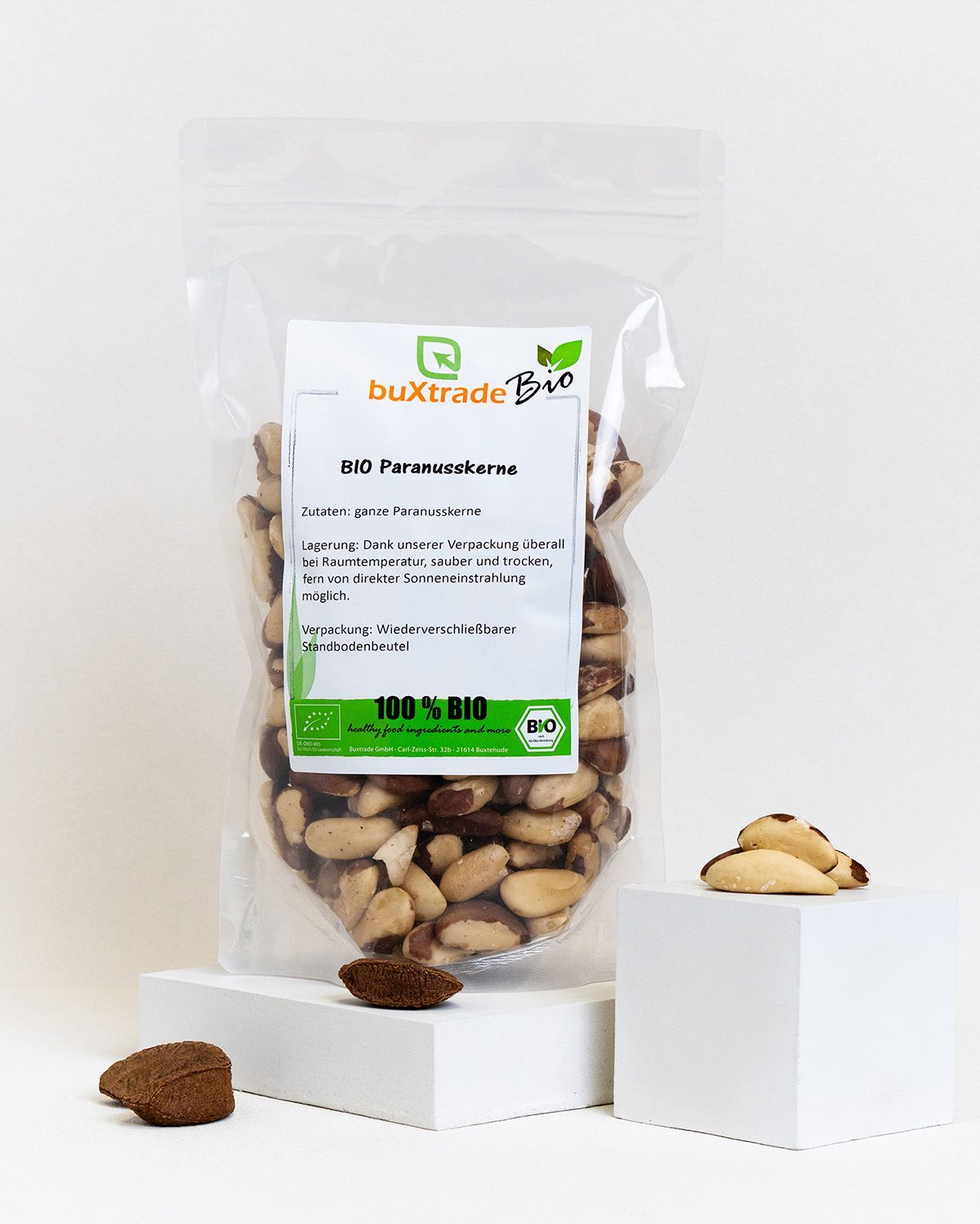 Verpackung von buXtrade Bio Paranusskerne. Tüte auf Podest. Einige Kerne liegen daneben.