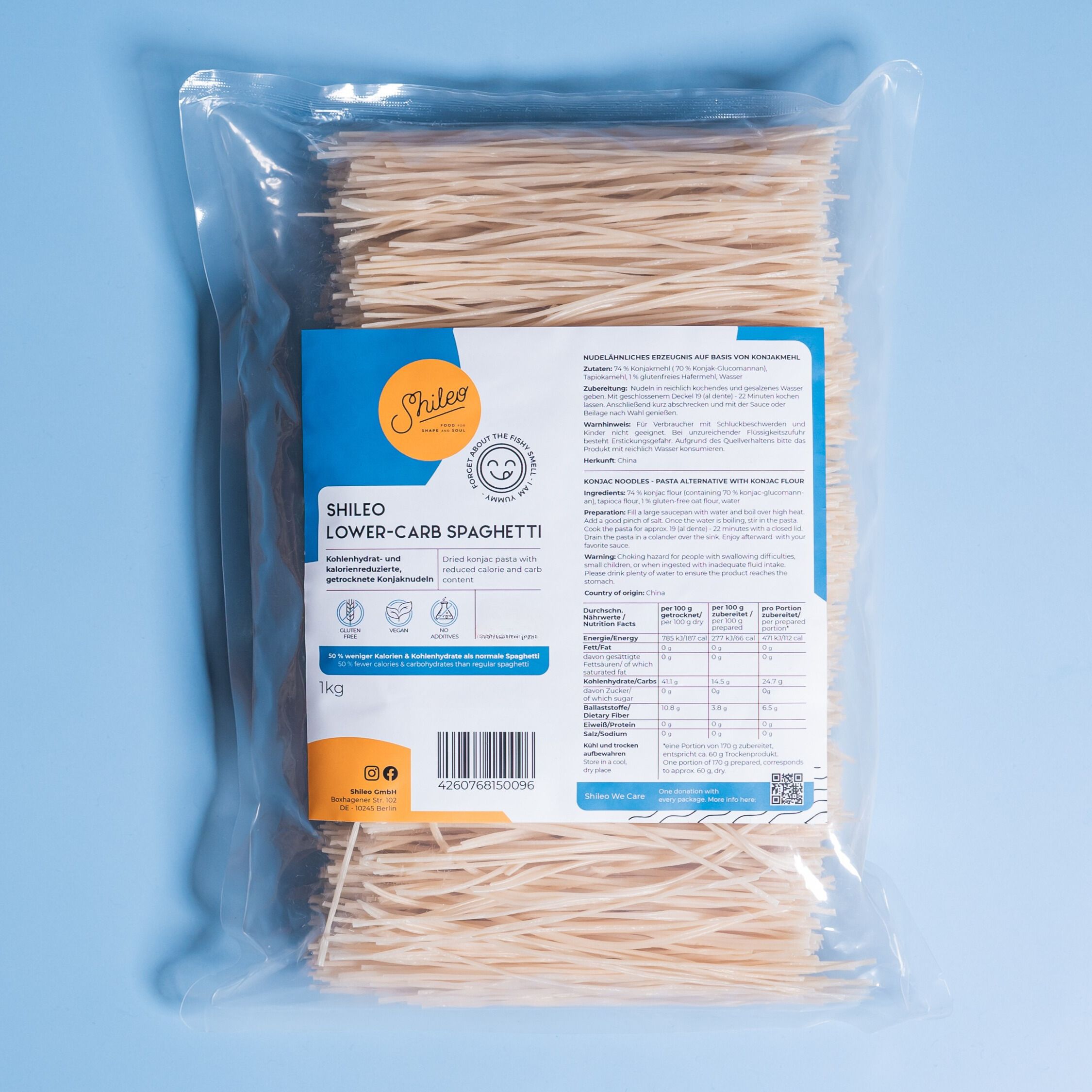 Klare Plastikverpackung mit SHILEO Lower-Carb Spaghetti. Produktinformationen auf der Verpackung. Hintergrund blau.
