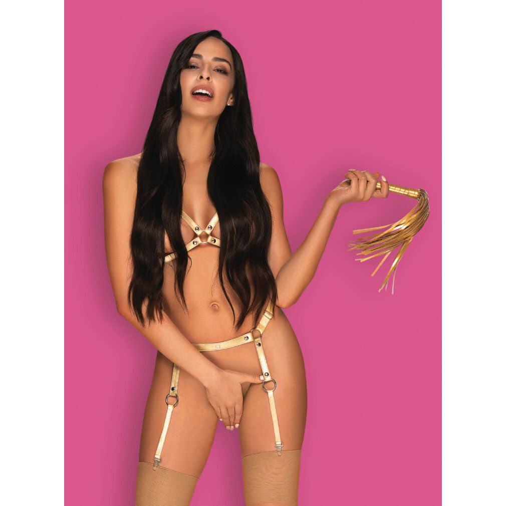 Frau in goldfarbener Dessous mit goldener Peitsche. Pinker Hintergrund.