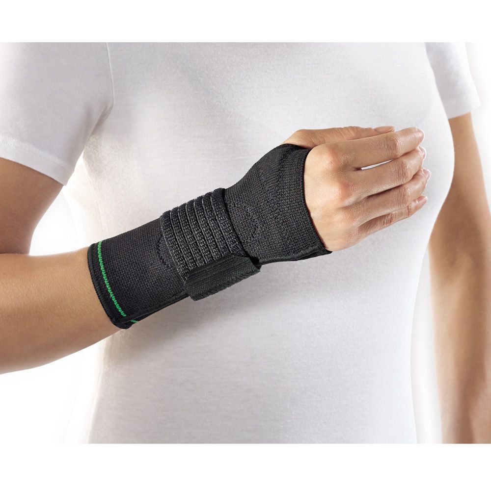 Schwarze Handgelenkbandage mit grünen Akzenten, die an einem Arm getragen wird.