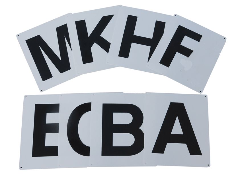 Weiße Schilder mit schwarzen Buchstaben. Buchstaben: E, C, B, A, K, H, F.