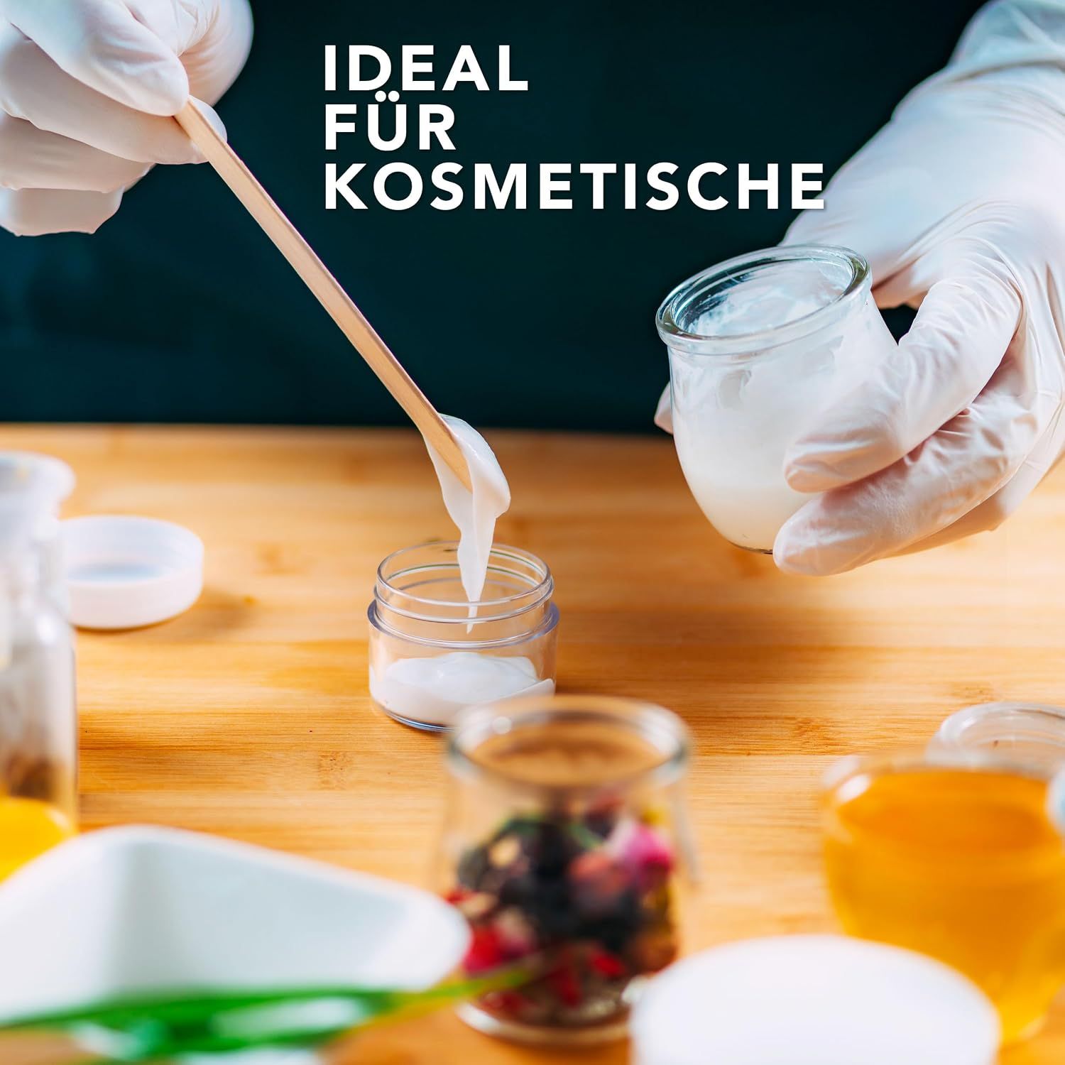 Hände mit Handschuhen mischen kosmetische Creme mit einem Holzspatel in einem Glasbehälter.