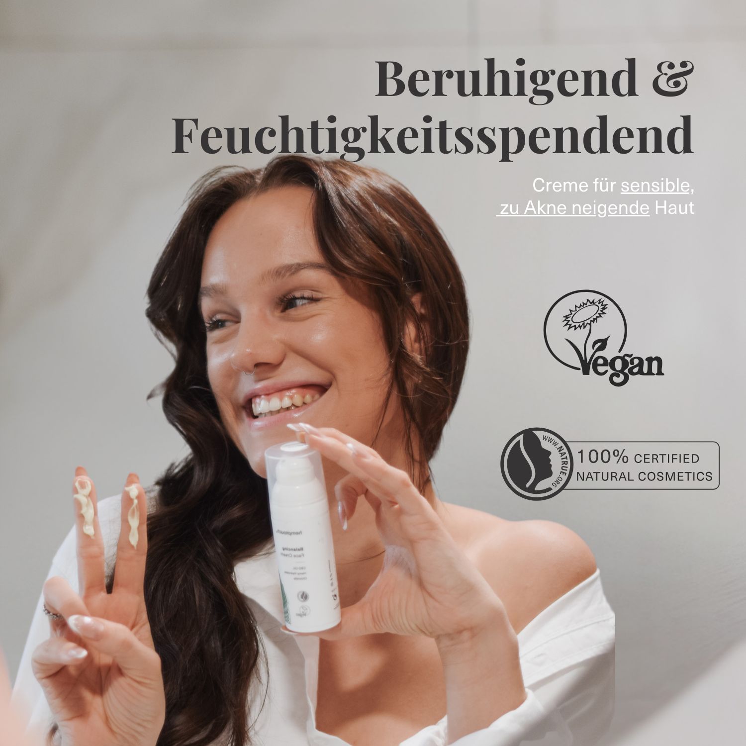 Frau hält Creme-Flasche. Text: Beruhigend & Feuchtigkeitsspendend, Creme für sensible, zu Akne neigende Haut, Vegan-Siegel, 100% Natural Cosmetics.