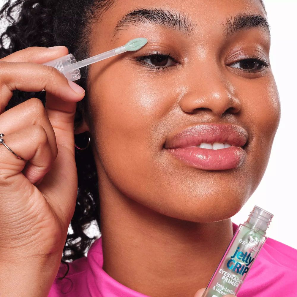 Frau trägt Essence Jelly Grip Lidschatten-Base auf. Produkt und Applikator sichtbar. Aufschrift: Jelly Grip, Eyeshadow Primer.