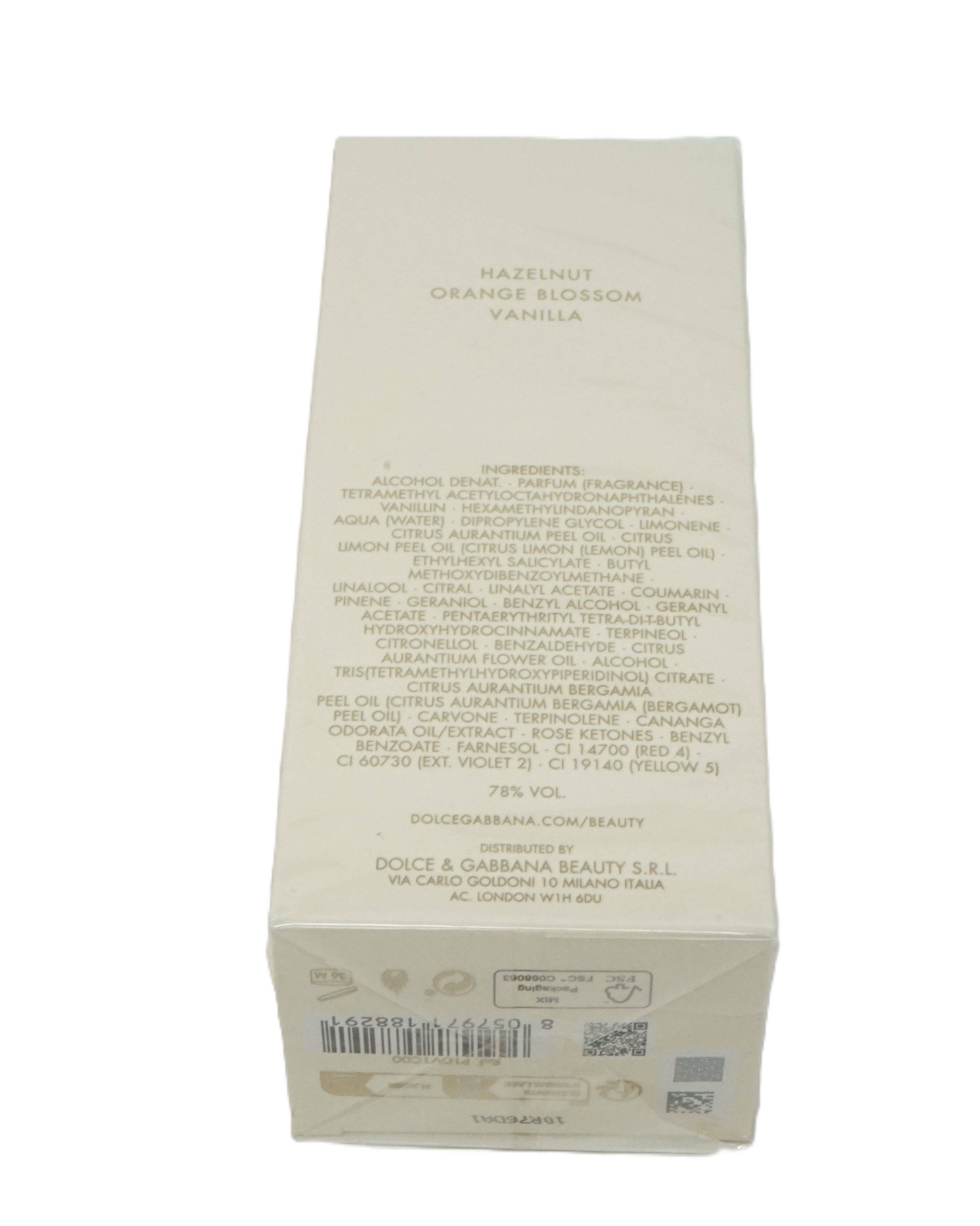 Parfümverpackung, cremefarben, mit Text. Zutatenliste und Markenname Dolce & Gabbana. Aufschrift: Hazelnut, Orange Blossom, Vanilla.