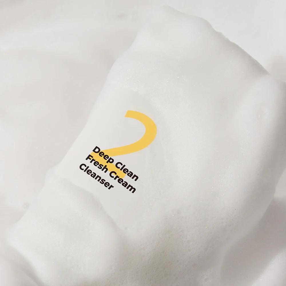 Weißer Schaum mit gelber Aufschrift "2 Deep Clean Fresh Cream Cleanser". Marke: numbuzin.