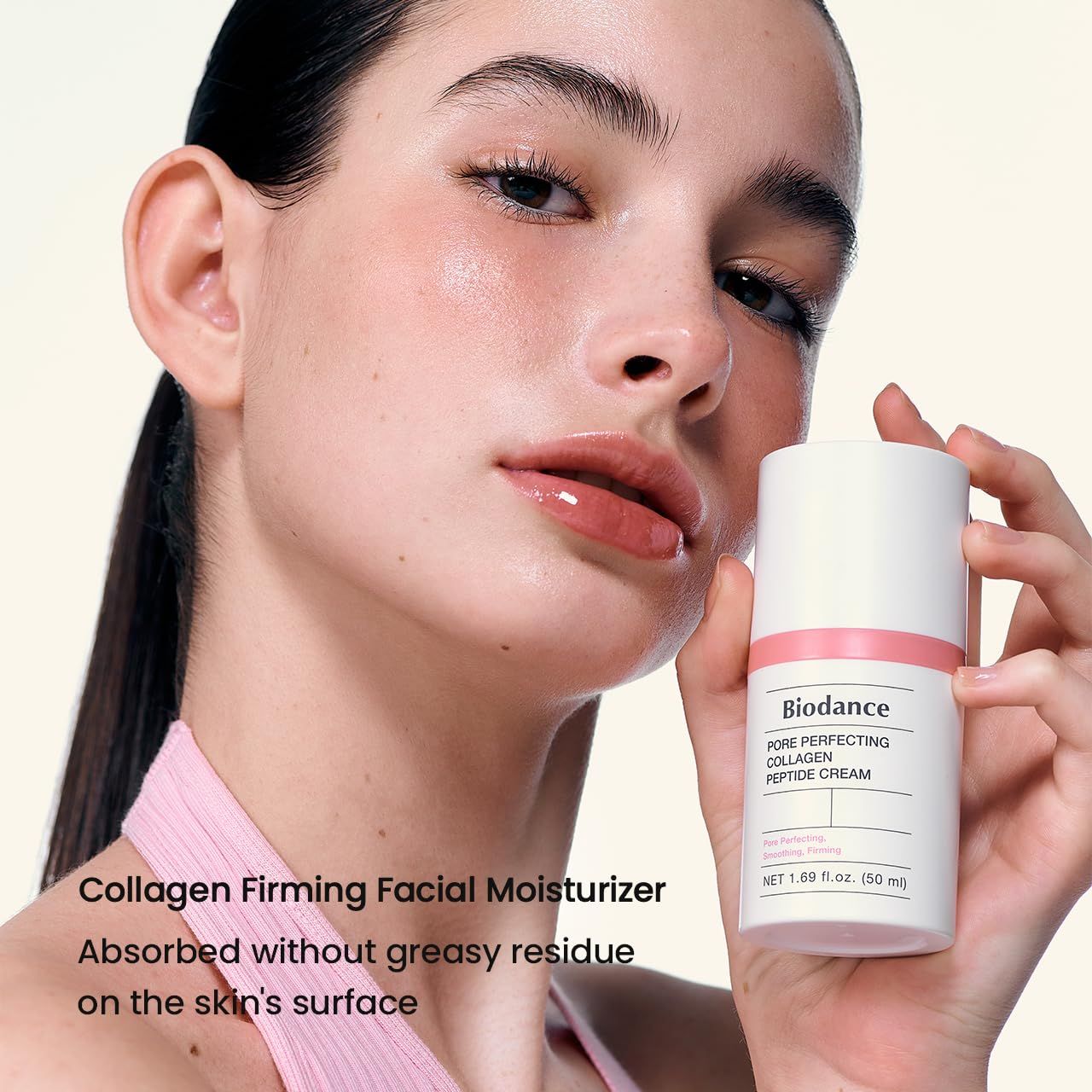 Weißer Tiegel mit rosa Akzenten. Aufschrift: Biodance Pore Perfecting Collagen Peptide Cream. Frau hält Produkt.