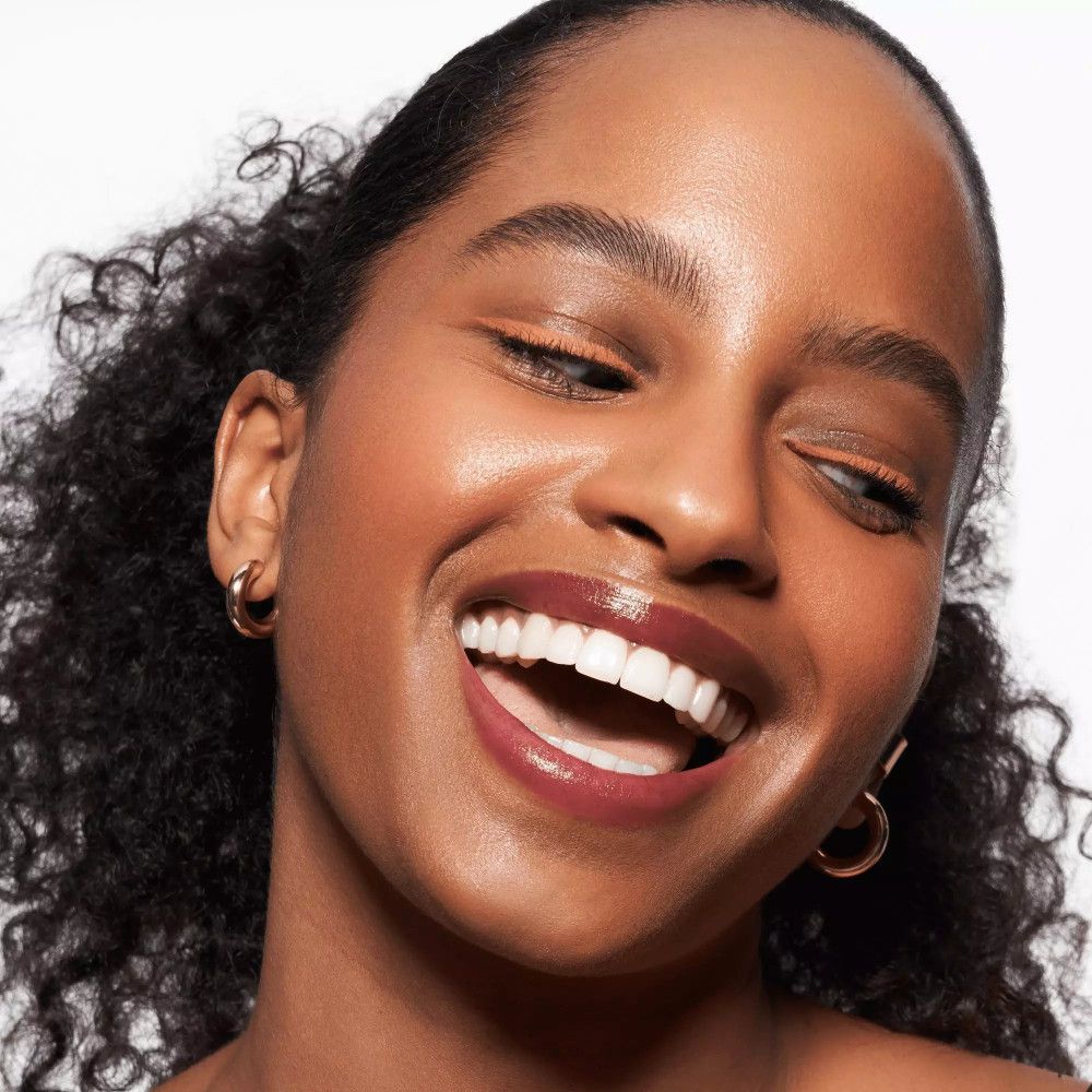 Frau mit gebräunter Haut und Lippenstift. Kajalstift-Strich am oberen Augenlid.