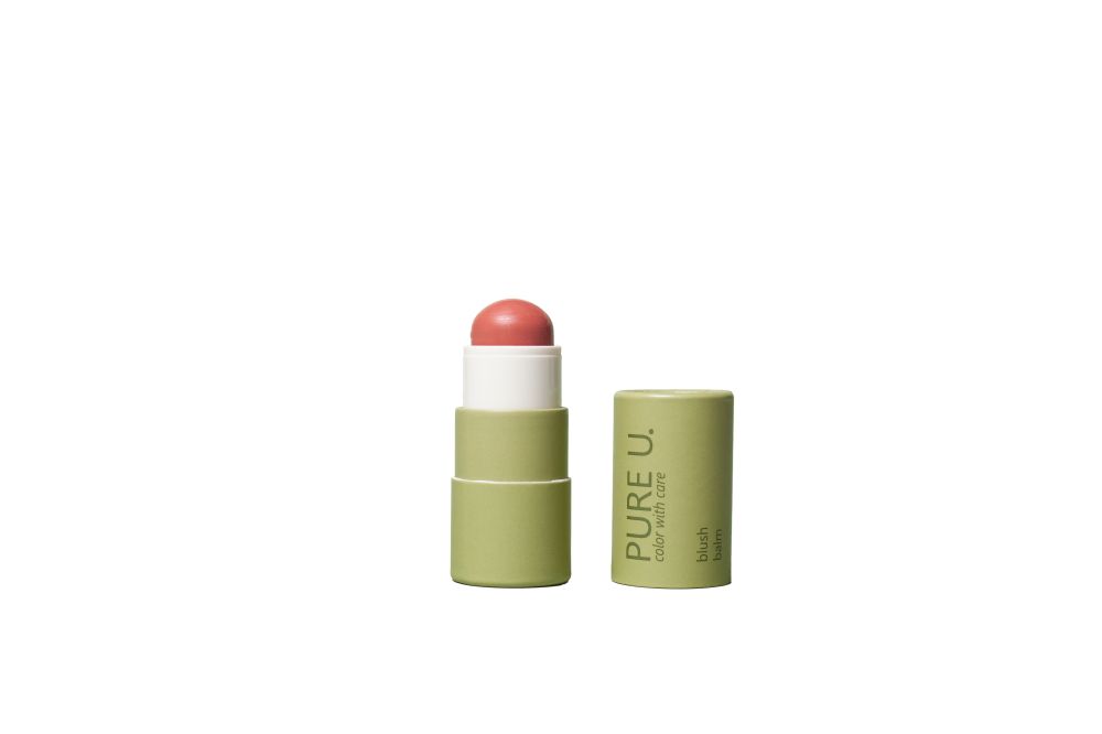 Blush Balm, geöffnet, mit rosafarbenem Produkt. Grüne Verpackung mit "PURE U." Aufschrift. Daneben die Kappe.