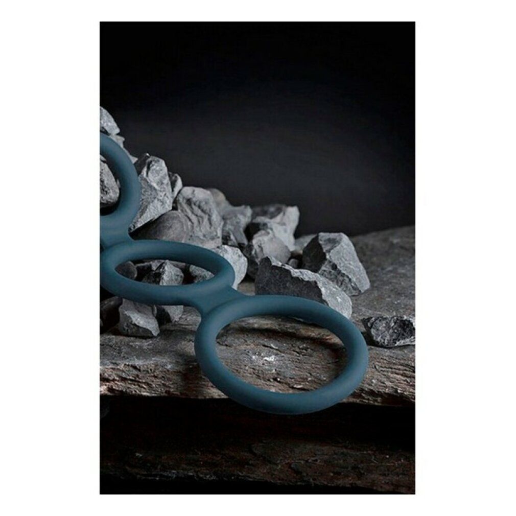 Blauer Penisring mit drei Ringen. Auf Steinuntergrund platziert.