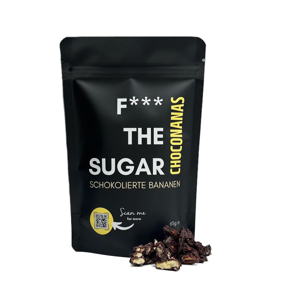 Schwarzer Beutel "F*** THE SUGAR" mit Schoko-Bananen. Aufschrift: Choconanas. QR-Code. Einige Schoko-Bananen daneben.