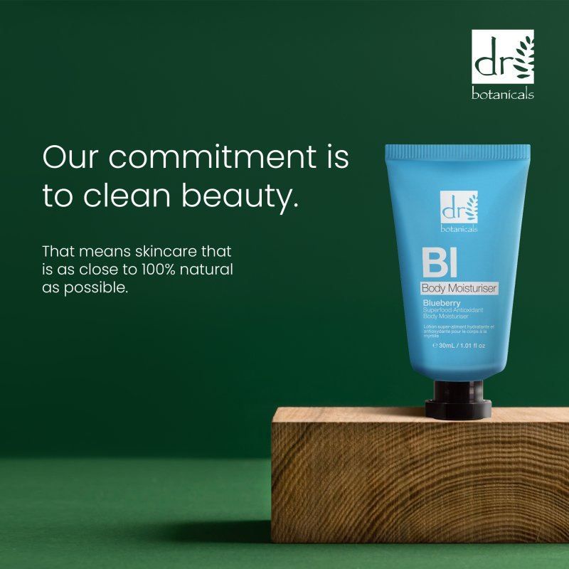 Dr. Botanicals Blaubeer-Körperlotion auf einem Holzblock mit Text über saubere Schönheit.