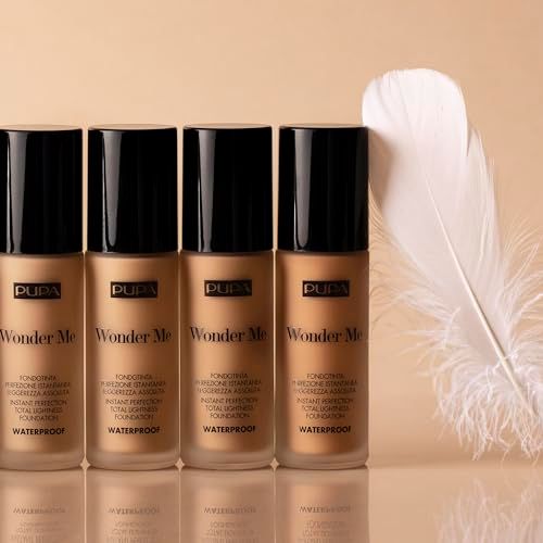Vier Pupa Wonder Me Foundation-Flakons mit schwarzem Deckel. Feder liegt daneben.