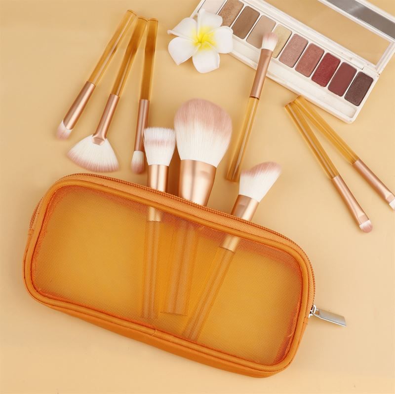 Make-up-Pinsel-Set mit transparenten, orangefarbenen Griffen, rosa Borsten, in einer orangefarbenen Tasche. Mit Lidschatten-Palette.