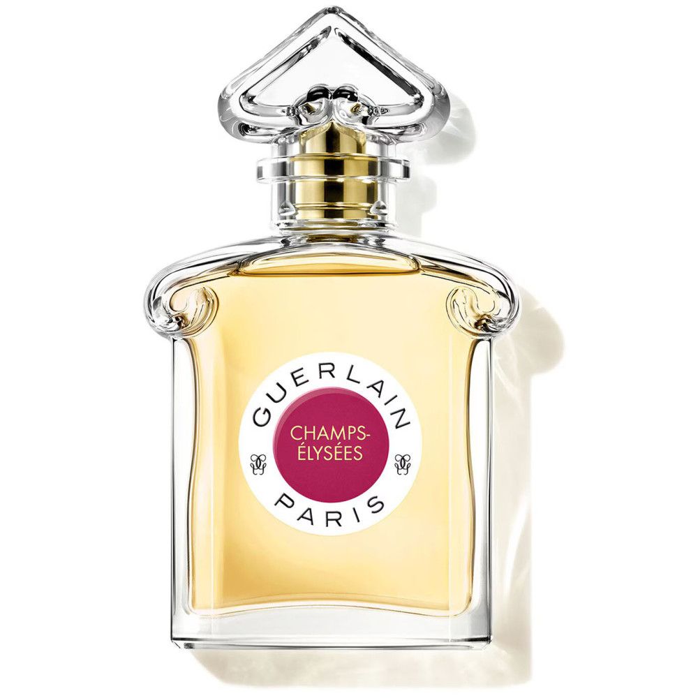 Parfümflakon mit rundem Etikett. Aufschrift: GUERLAIN, CHAMPS-ÉLYSÉES, PARIS. Rosa Kreis. Transparenter Glasflakon mit goldfarbenem Verschluss.