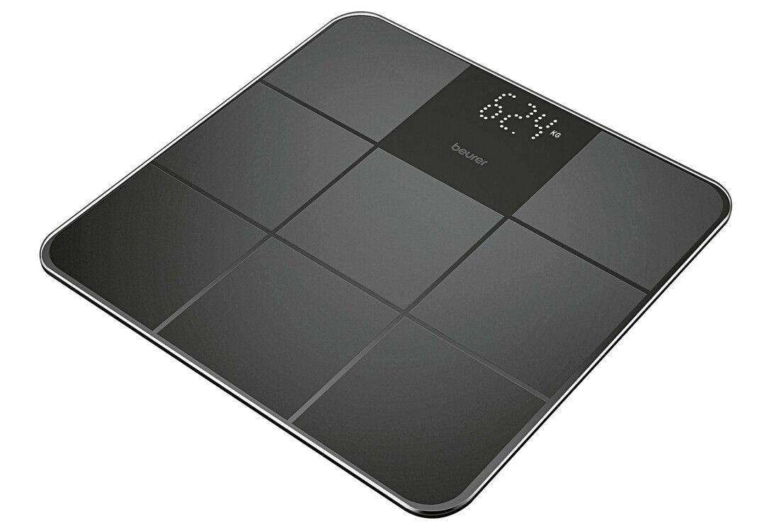 Schwarze digitale Personenwaage. Marke Beurer. Zeigt 62,4 kg an. Quadratische Form mit neun Feldern. Glasoberfläche.