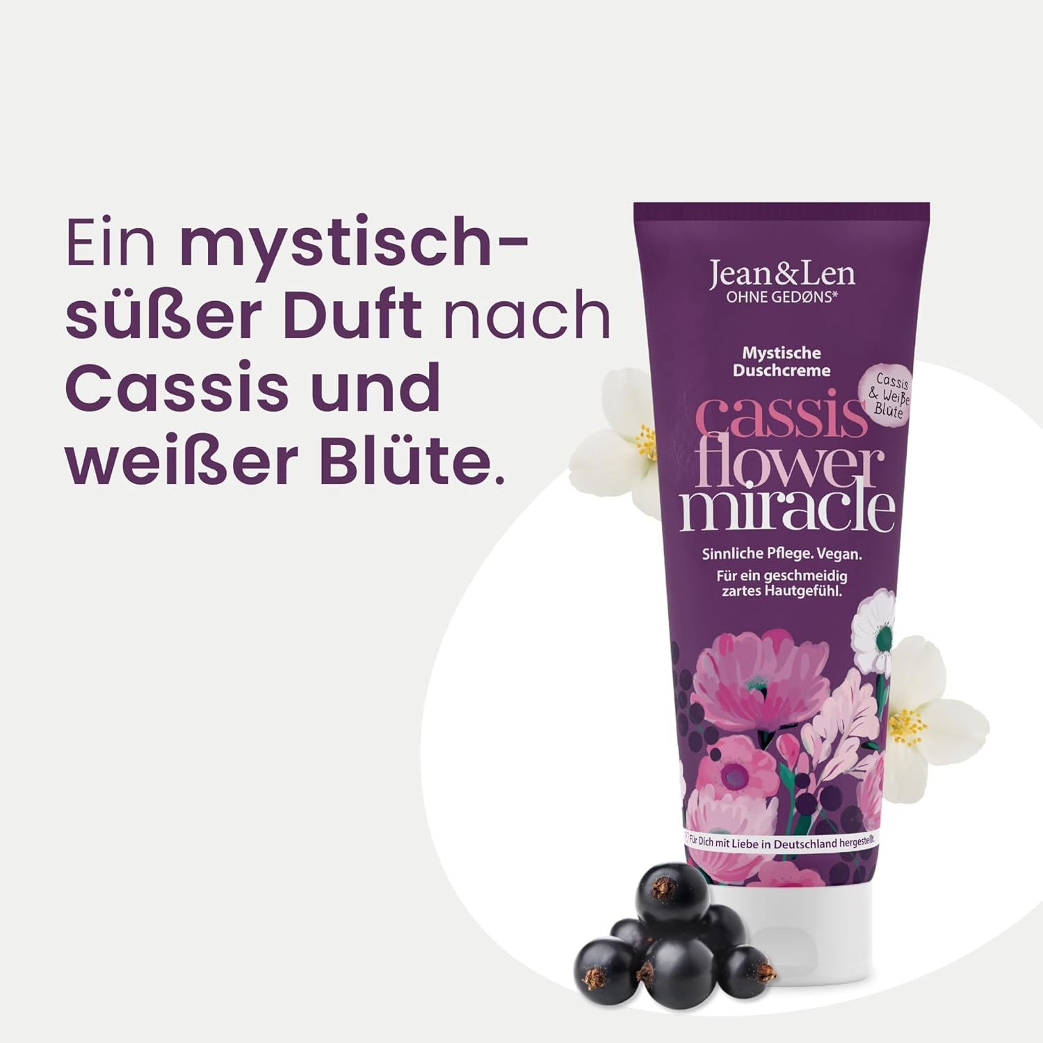 Lila Tube mit Produktinformationen, daneben schwarze Johannisbeeren und Jasminblüten. Text: Ein mystisch-süßer Duft nach Cassis und weißer Blüte.