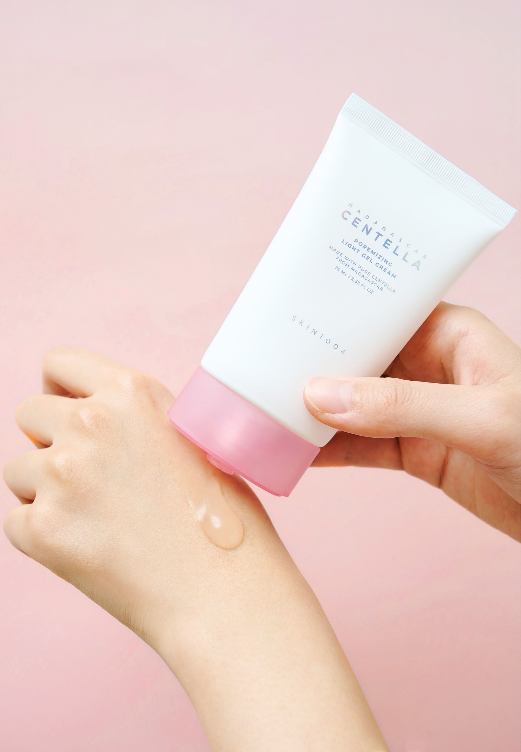 Hände halten Tube. Gel wird auf die Hand aufgetragen. Aufschrift: MADAGASCAR CENTELLA Poremizing Light Gel Cream. Marke SKIN1004.