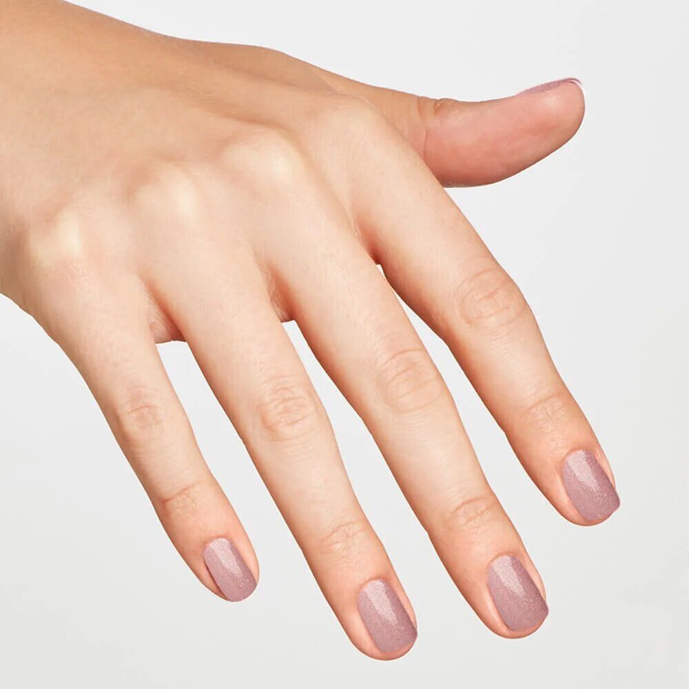 Hand mit lackierten Nägeln. Rosa Nagellack auf den Fingernägeln.