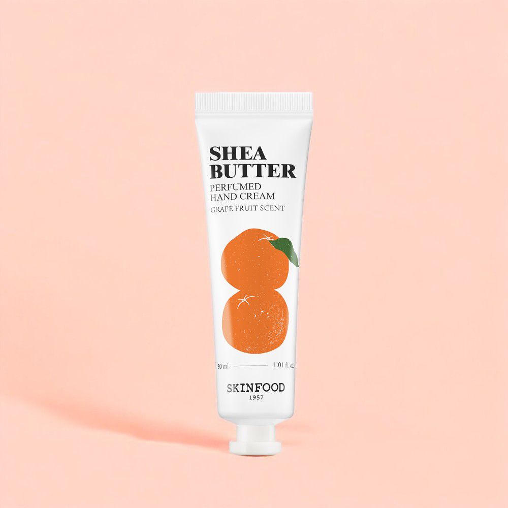 Weiße Tube Shea Butter Handcreme, Grapefruit-Duft. Illustration von Orangen. SKINFOOD-Logo. Auf rosa Hintergrund.