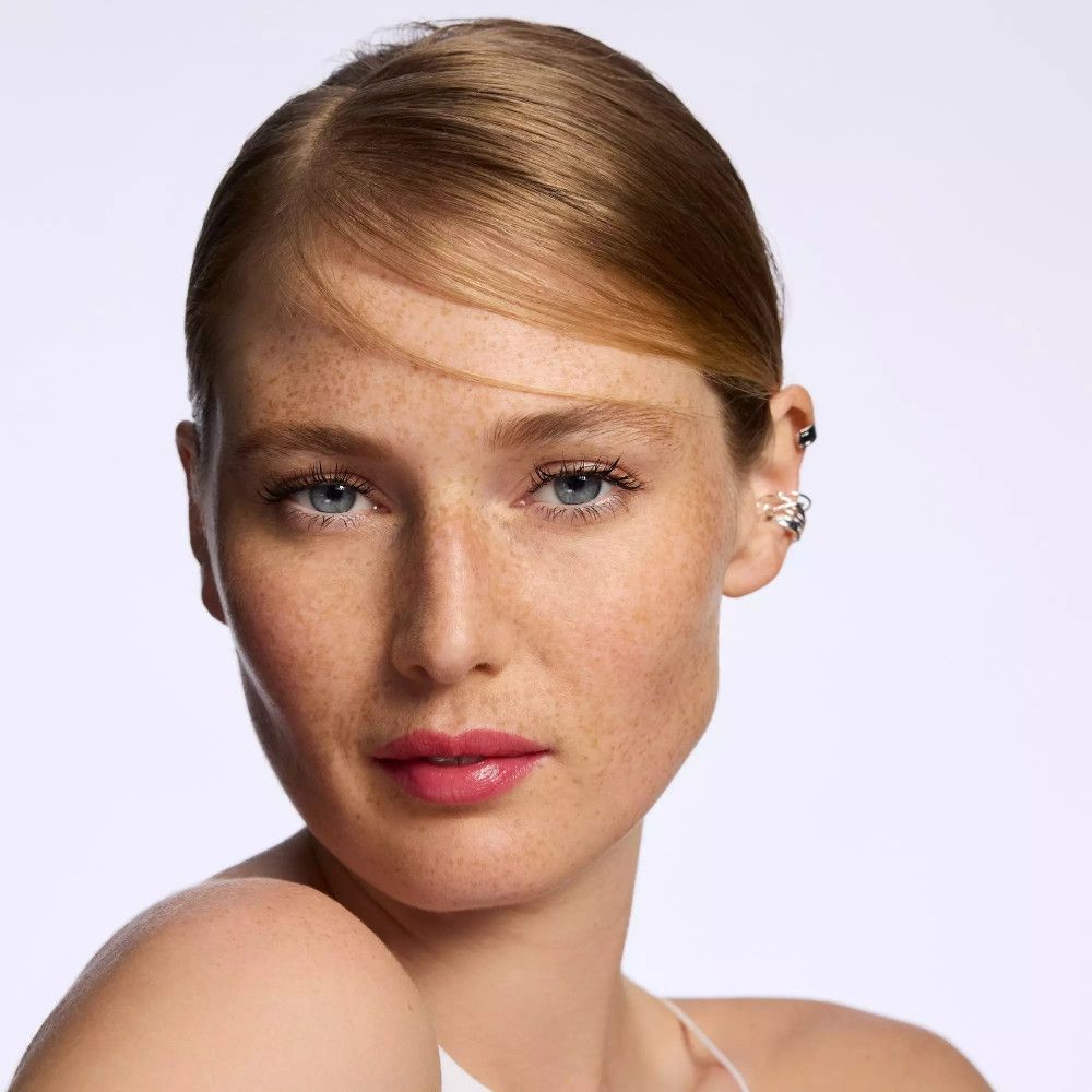 Porträt einer Frau mit Sommersprossen. Lippen mit rotem Lippenbalsam betont.