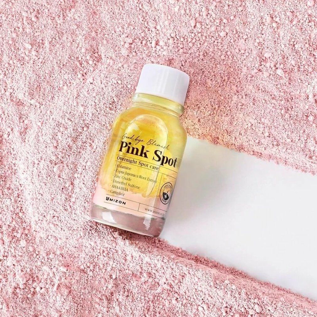Fläschchen mit rosa Flüssigkeit auf rosa Pulver. Aufschrift: Good bye Blemish Pink Spot. Enthält Inhaltsstoffe wie Calamin.