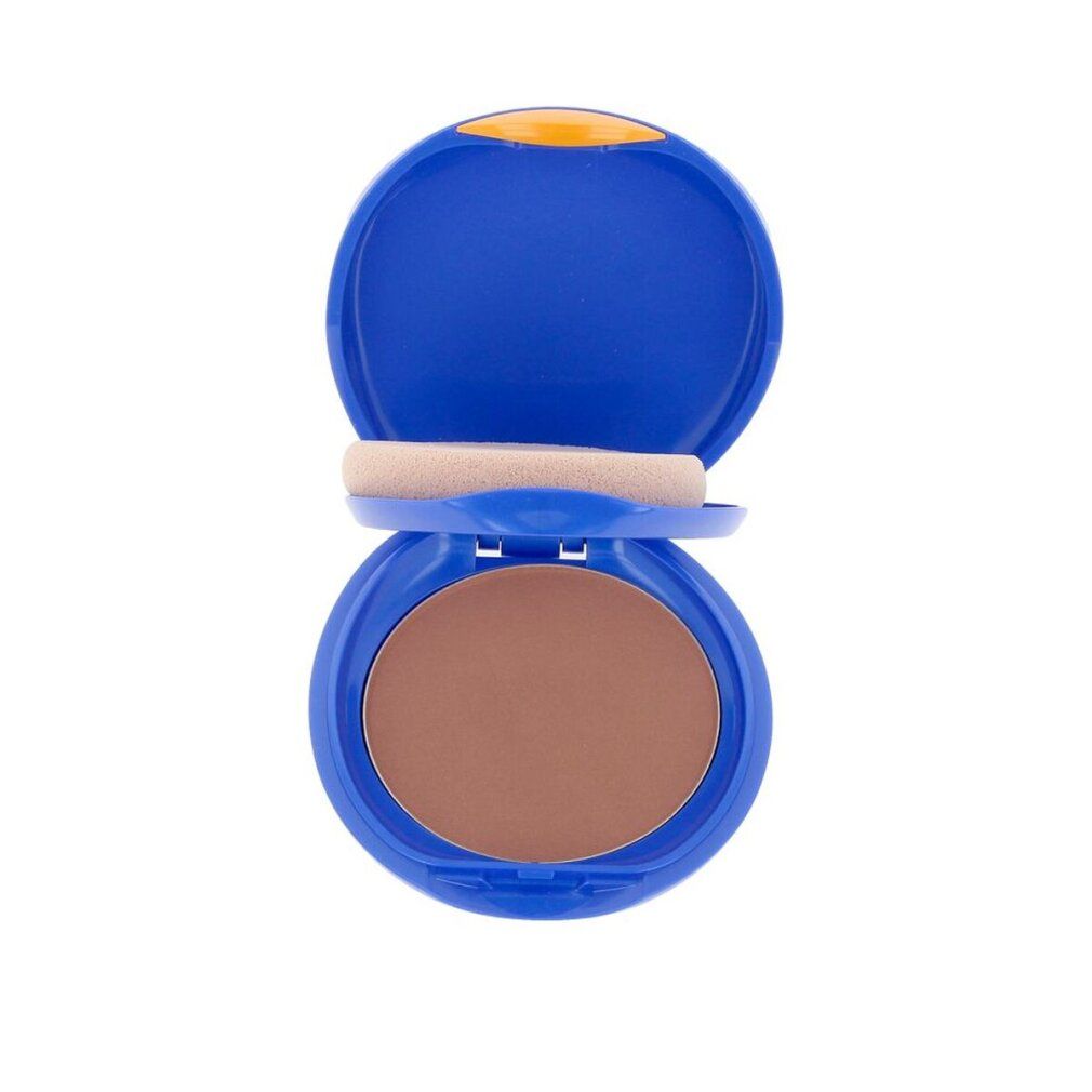 Blauer Kompakt-Make-up-Behälter, geöffnet. Enthält Schwamm und braunen Puder.