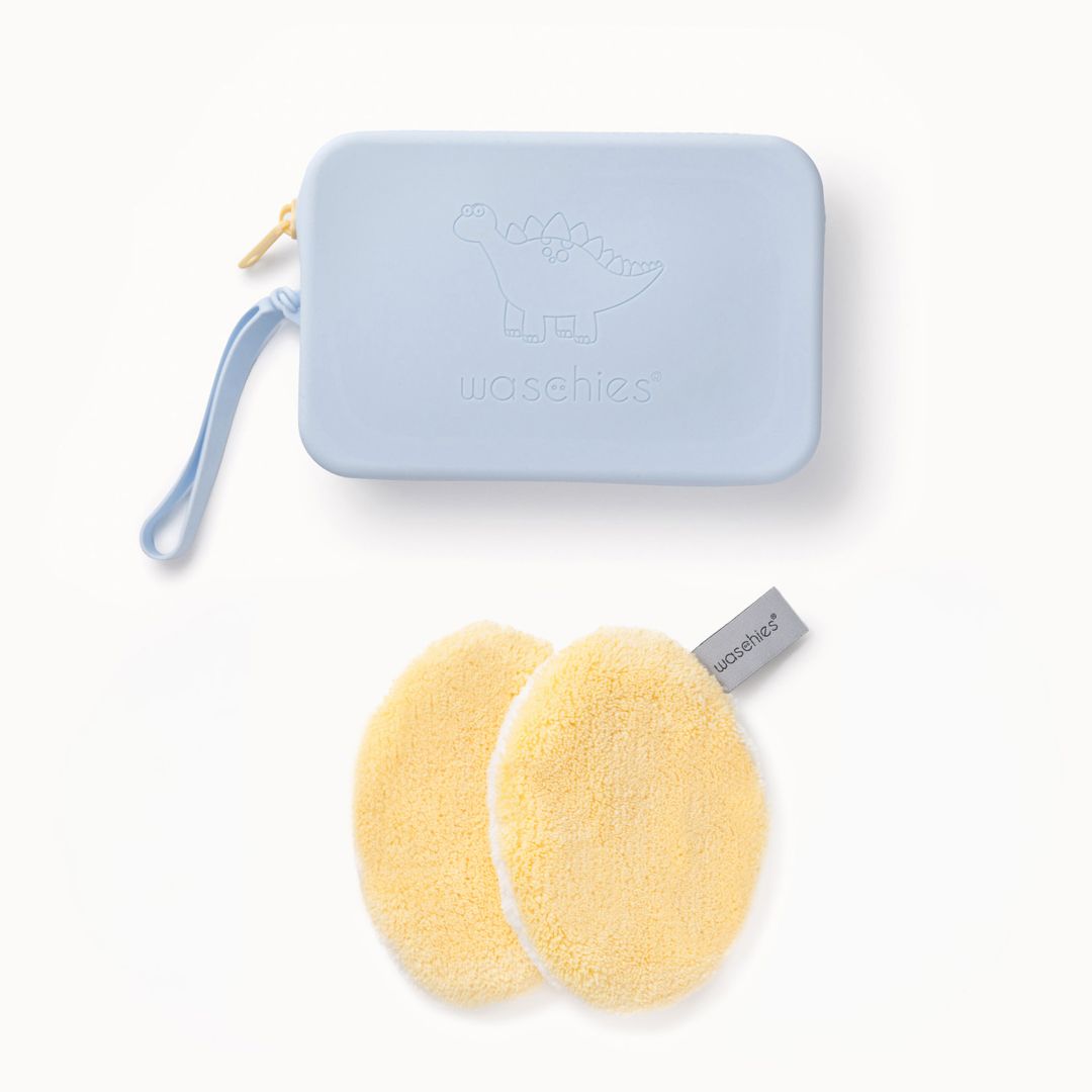Hellgelbe Waschpads und hellblaue Tasche mit Dinosaurier-Motiv. Waschies-Logo auf Tasche und Pads.