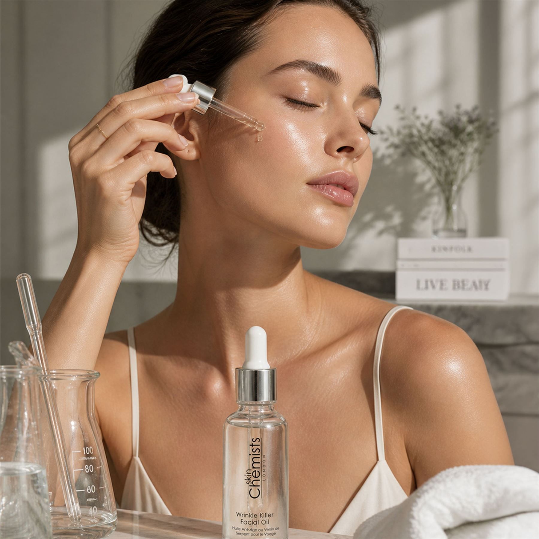 Frau trägt SkinChemists Faltenbekämpfendes Anti-Aging-Gesichtsöl mit Pipette auf.