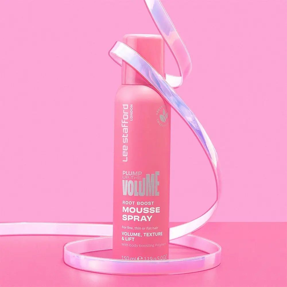 Rosa Sprühflasche mit Produktnamen und Logo. Dekoband umwickelt die Flasche. Hintergrund ebenfalls rosa.