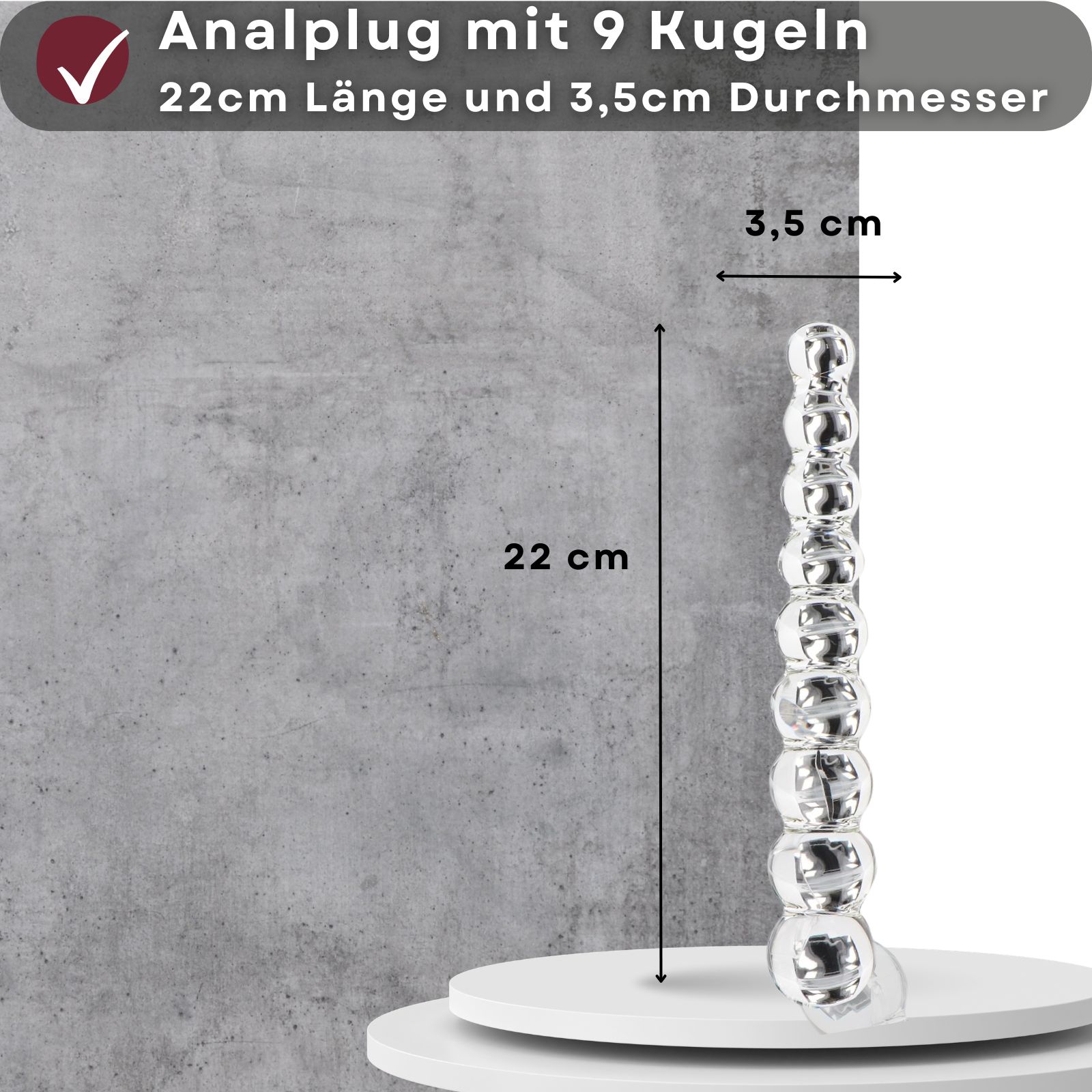 Analplug mit 9 Kugeln, 22 cm lang, 3,5 cm Durchmesser. Auf Podest, vor Betonwand.