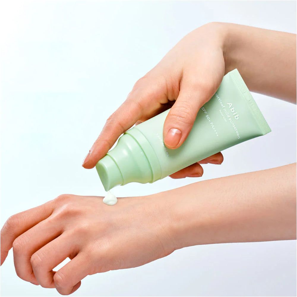 Eine Hand gibt Abib Heartleaf Mild Sonnenschutzmittel SPF 50+ PA++++ auf eine andere Hand.