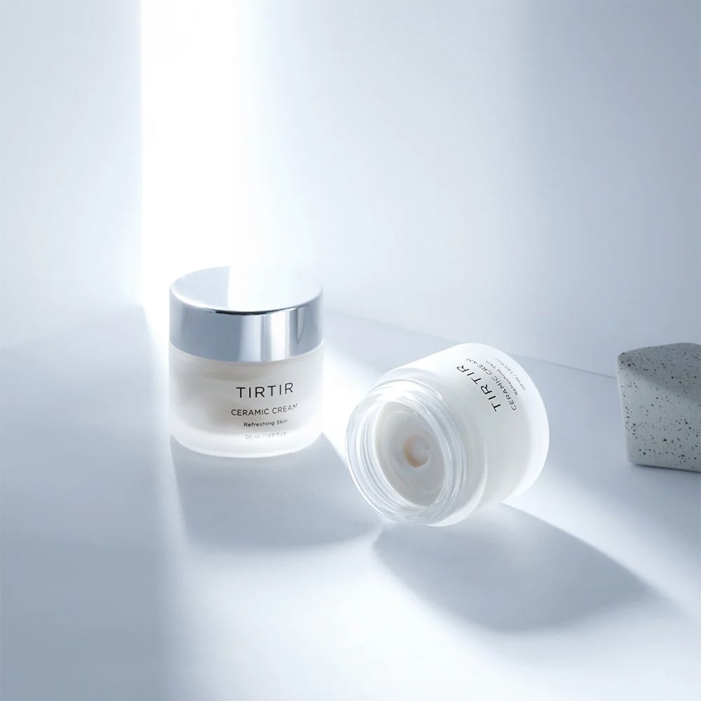 Zwei Tir Tir Ceramic Cream Tiegel auf einer hellen Oberfläche mit Lichteffekten.