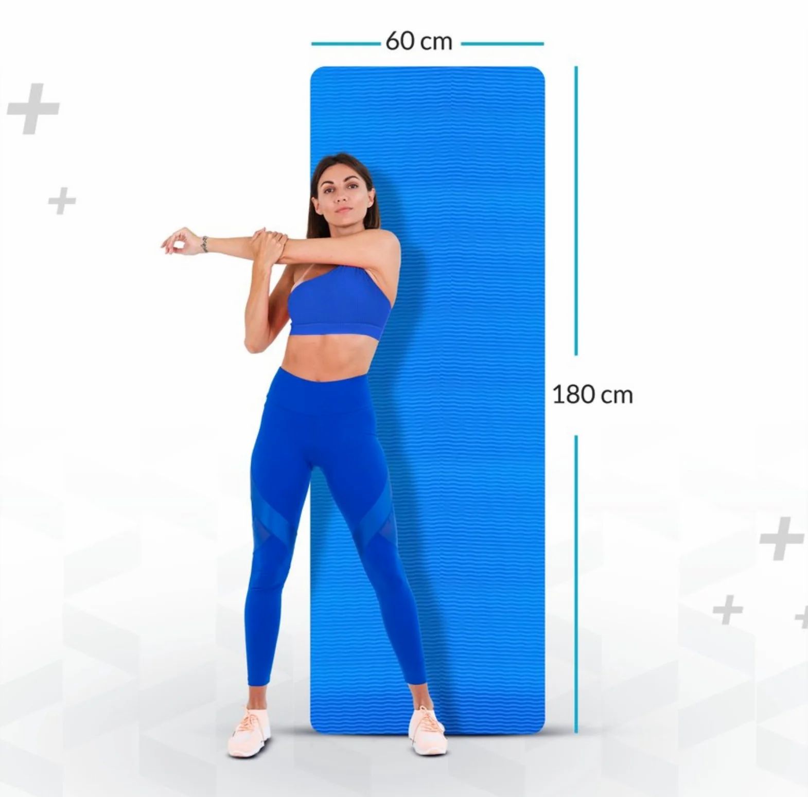 Blaue Yogamatte, 180 x 60 cm. Frau dehnt sich neben der Matte. Blaue Sportkleidung. Abmessungen sind angegeben.