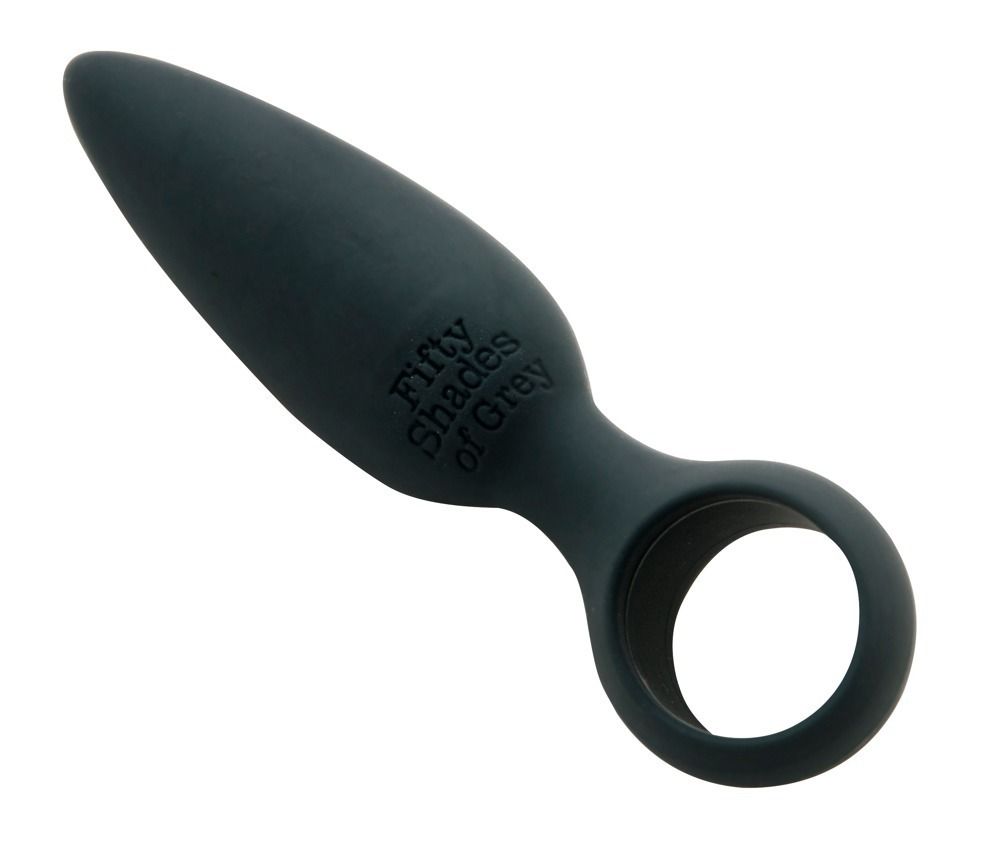 Grauer Analplug mit Ring. Aufschrift "Fifty Shades of Grey". Kegelförmiger Kopf, abgerundete Basis mit Ring.