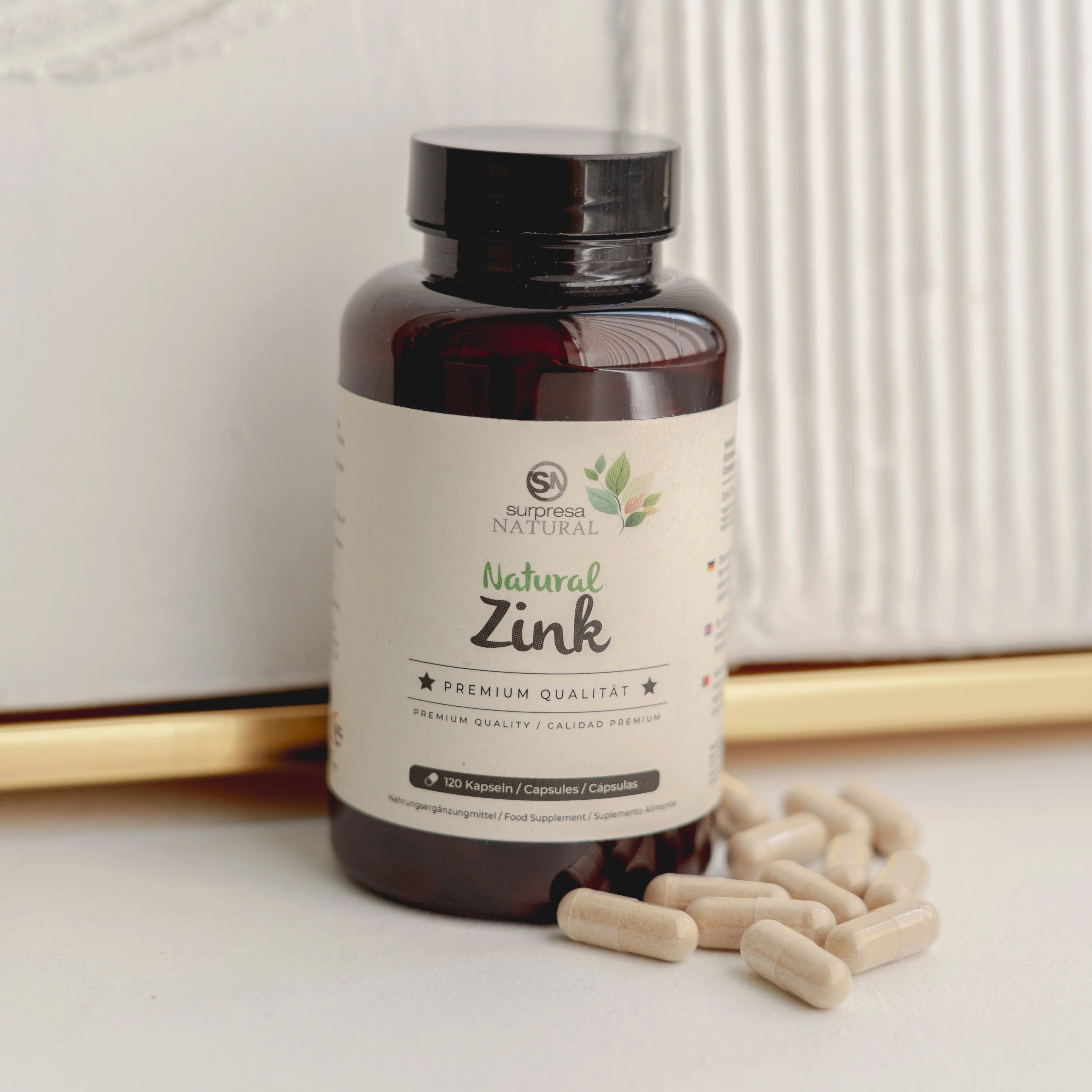 Braune Flasche mit Etikett und Kapseln daneben. Aufschrift: Surpresa Natural, Natural Zink, 60 Kapseln. Premium Qualität.