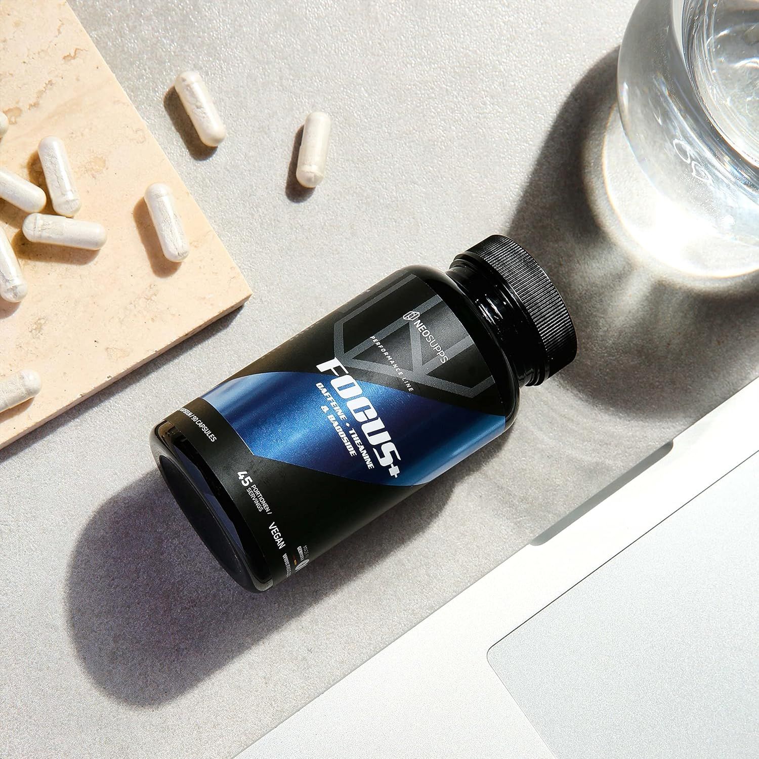 Schwarze Flasche mit Focus+ und Kapseln. Aufschrift: Neosupps, Focus+, Koffein, Theanin & Bacoside. 45 Portionen, vegan.