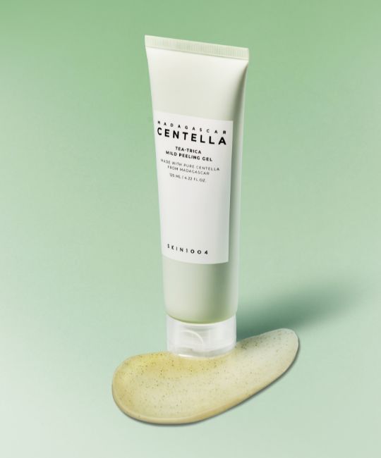 Grüne Tube mit weißem Etikett und Produktmasse daneben. Aufschrift: MADAGASCAR CENTELLA, Tea-Trica Mild Peeling Gel.