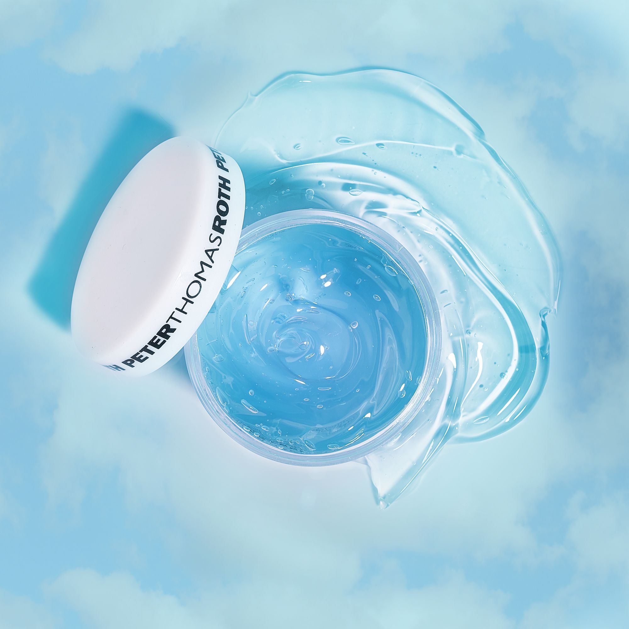 Geöffneter blauer Tiegel mit weißem Deckel. Gel daneben. Aufschrift: Peter Thomas Roth. Hintergrund: blauer Himmel mit Wolken.