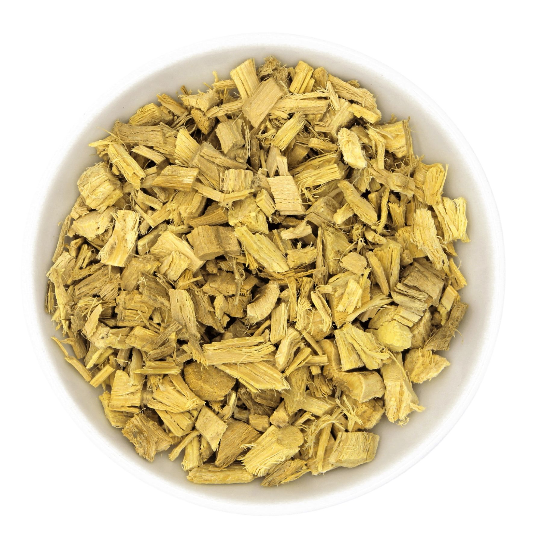 Draufsicht auf eine weiße Schüssel gefüllt mit gehackten, hellbraunen Süßholzstücken. Die Stücke sind unregelmäßig geformt und strukturiert.