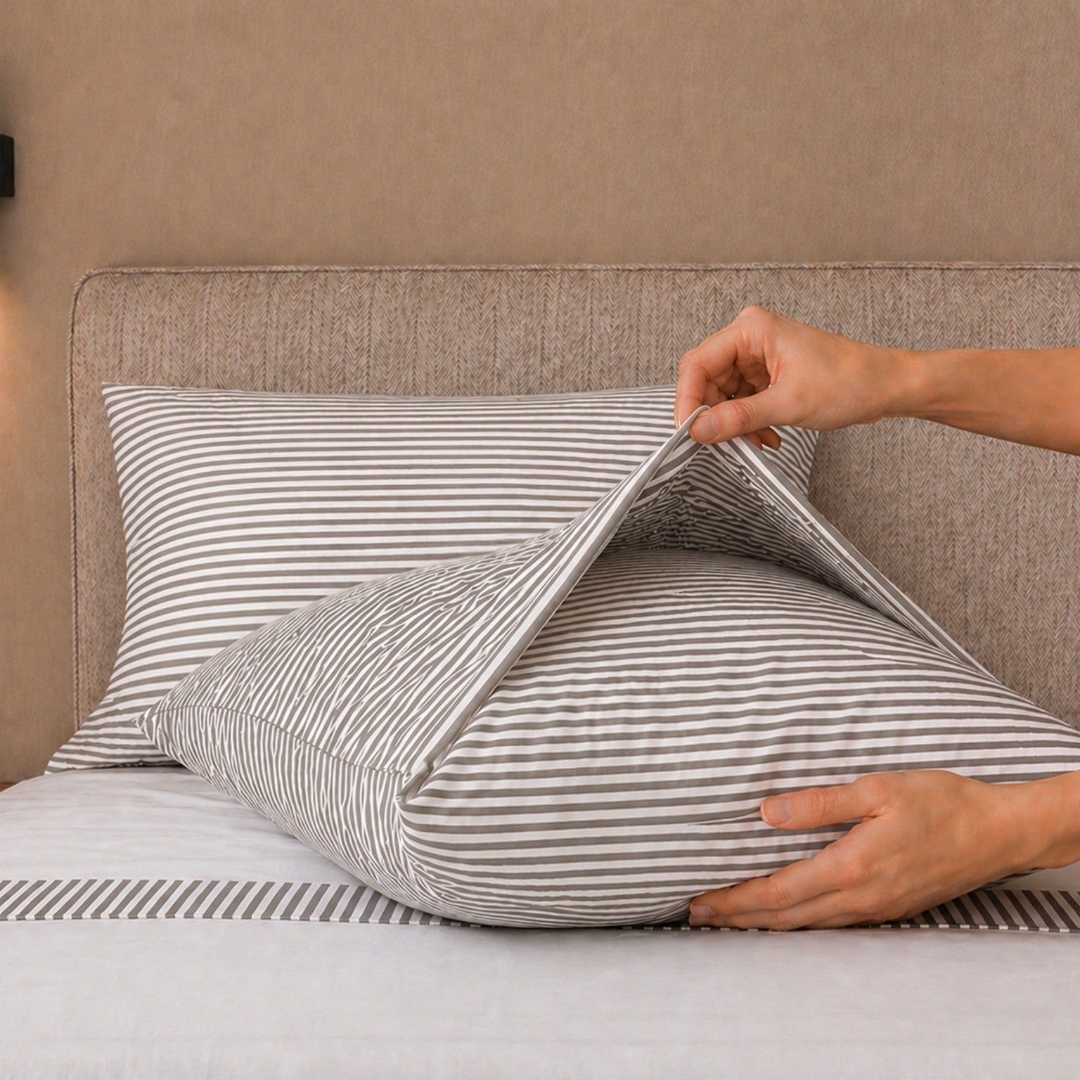 Bett mit gestreiften Kissen und einem gestreiften Bettlaken.