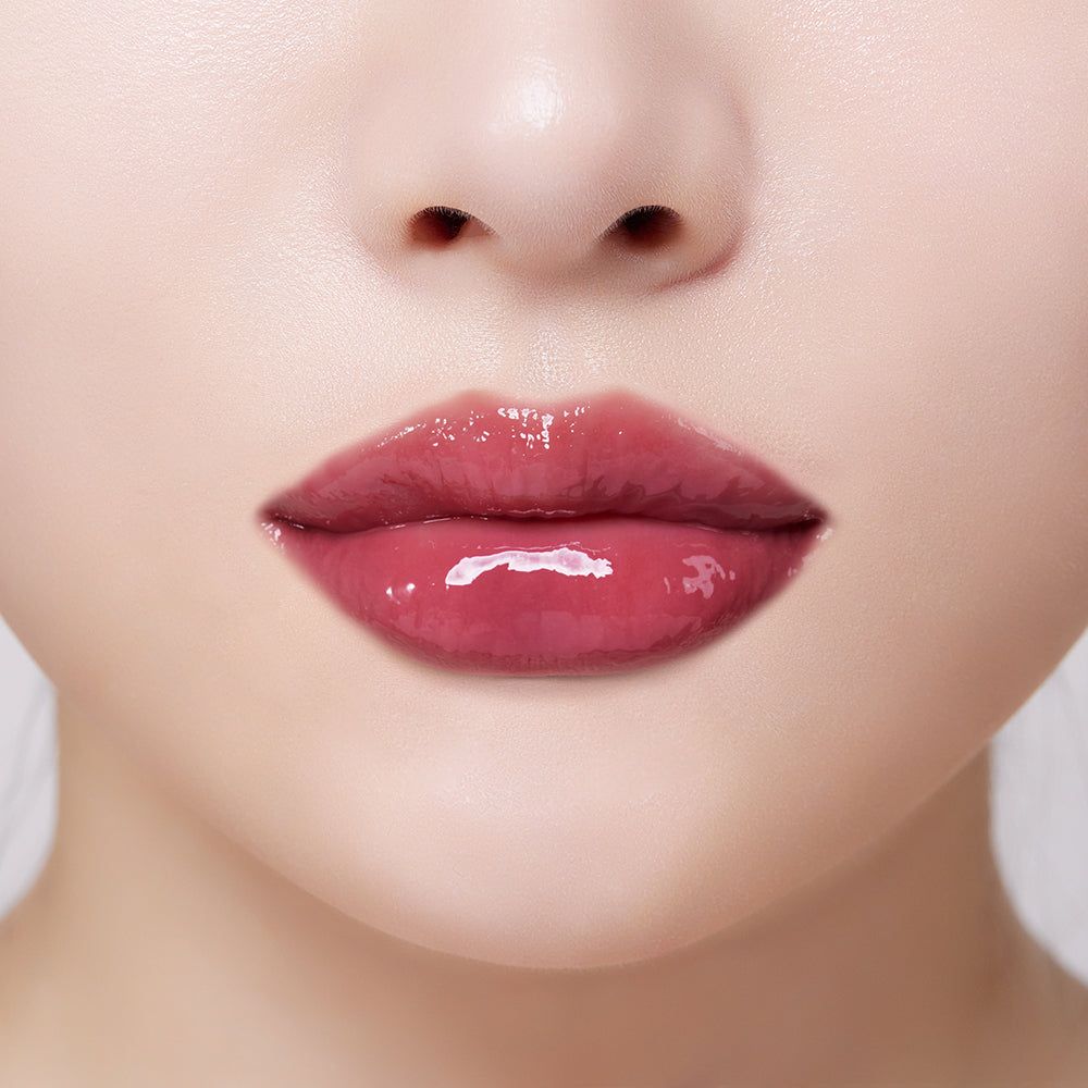 Nahaufnahme von Lippen mit glänzendem, rosafarbenem Lippenstift. Die Lippen sind leicht geöffnet.