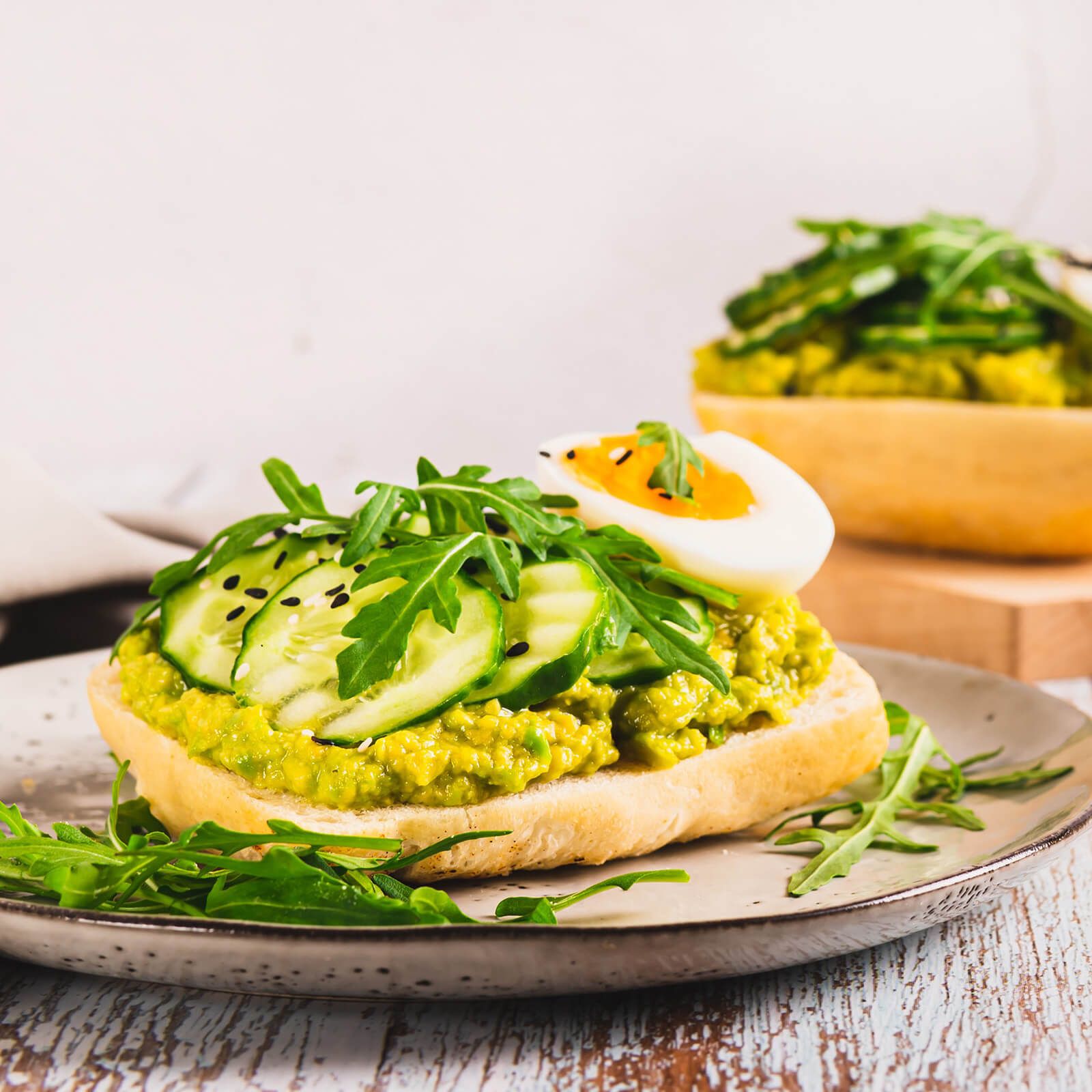 Ciabattini mit Avocado-Creme, Gurkenscheiben, Ei und Rucola.