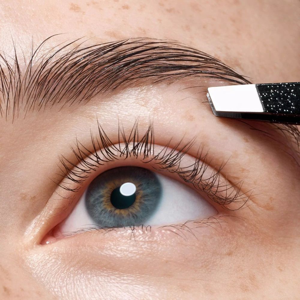 Nahaufnahme eines Auges. Eine Pinzette zupft Augenbrauenhaare. Schwarze Pinzette mit silberner Spitze.