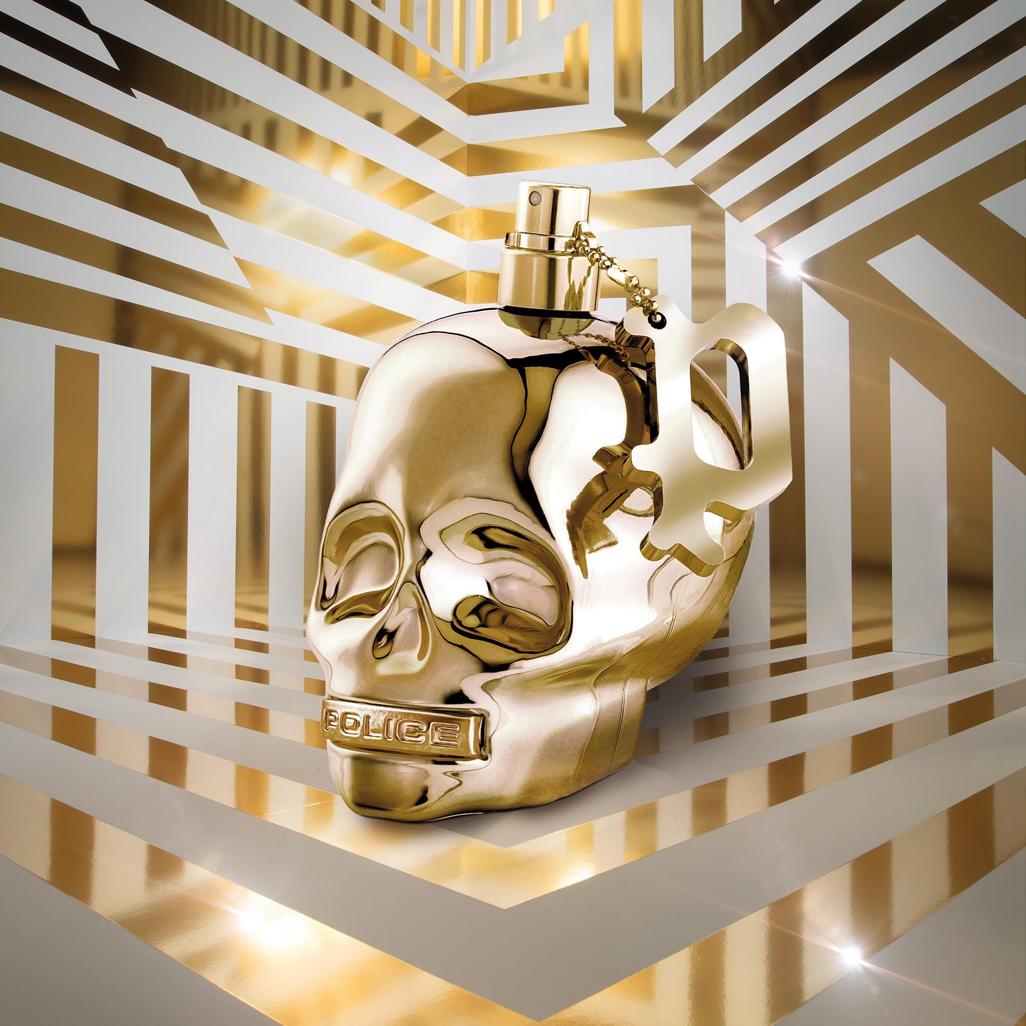 Goldfarbener Flakon in Totenkopf-Form. Mit Sprühkopf und Anhänger. Aufschrift: POLICE.