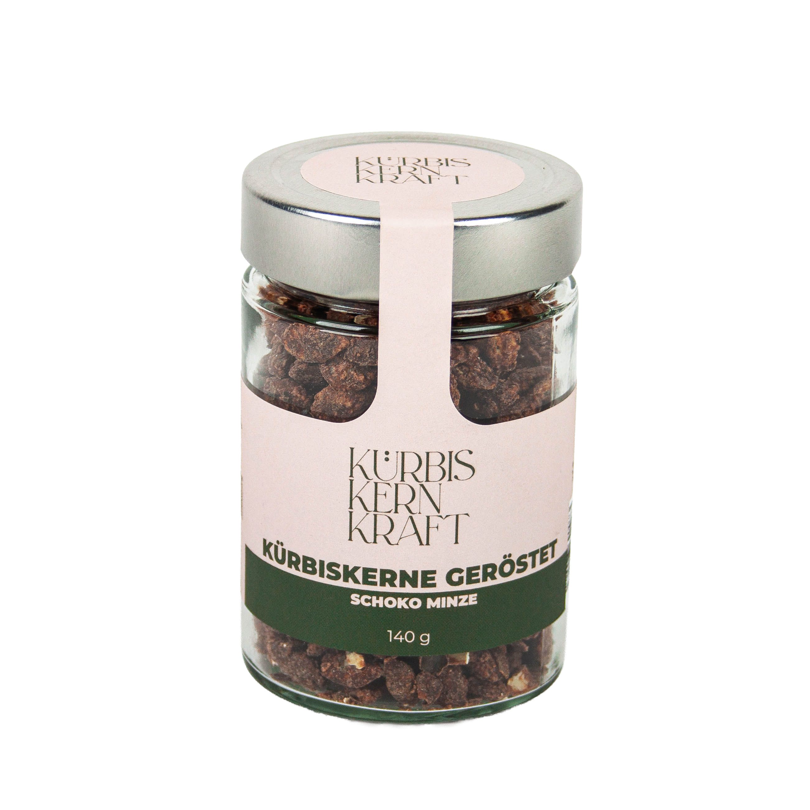 Glas mit gerösteten Kürbiskernen Schoko-Minze. Rosa Etikett mit Schriftzug Kürbis Kern Kraft, 140 g.