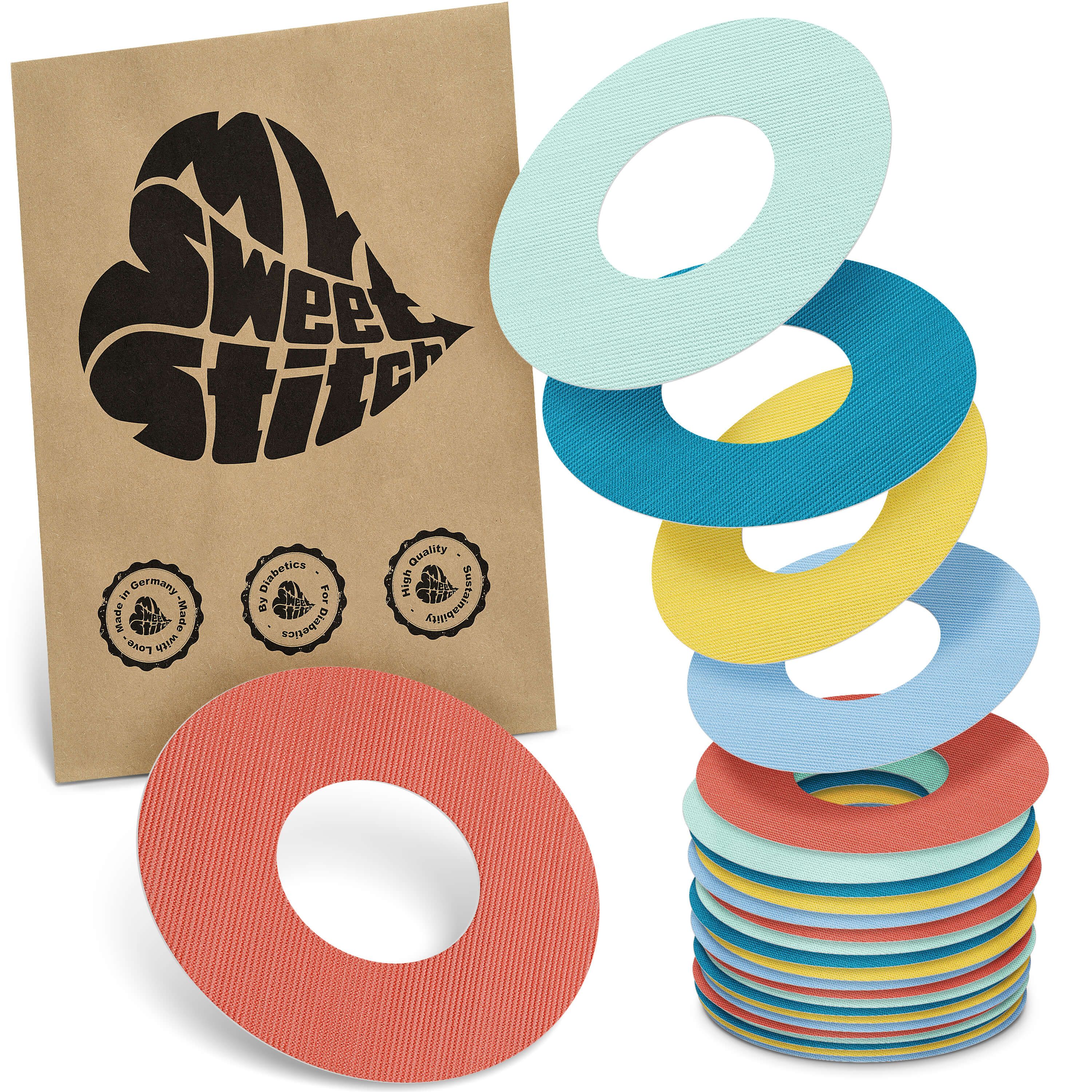 Mehrfarbige Fixierringe. Braune Verpackung mit Logo "MySweetStitch". Ringe in Rot, Gelb, Blau, Türkis. Zertifizierungen.
