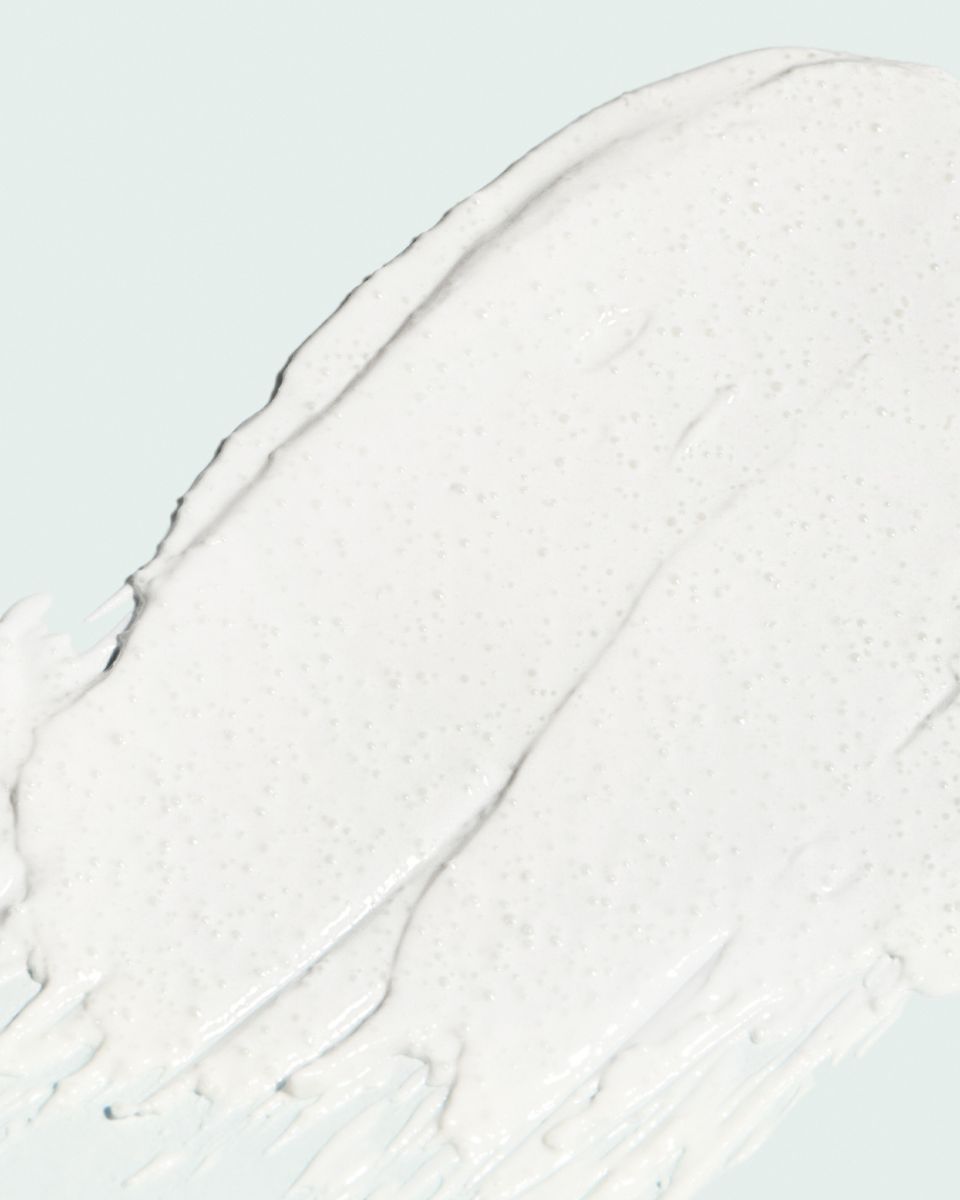 Nahaufnahme einer weißen, cremigen Substanz mit unebener Textur. Auf hellem Hintergrund.