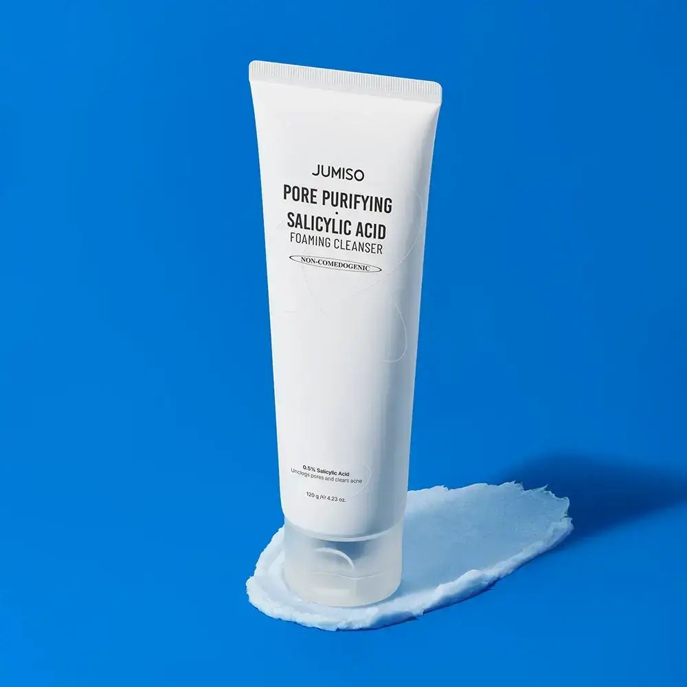 Weiße Tube mit Schaum auf blauem Hintergrund. Aufschrift: JUMISO Pore Purifying Salicylic Acid Foaming Cleanser.