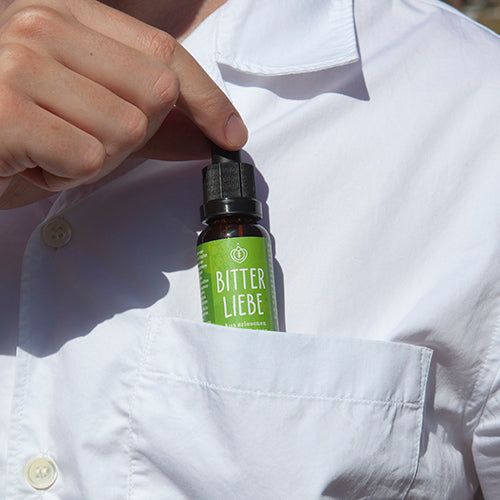 Eine Flasche BitterLiebe-Tropfen in einer Hemdtasche.
